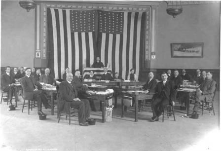 The First Territorial House of Representatives at the Elks Hall in Juneau.  Presiding officer E. B. Collins is standing in the center, circa March 1913/>
<table border=