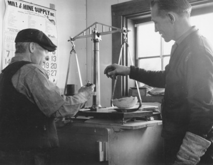 George Lynch (left) and a young engineer weighing a retort sponge at the Independence Mine, circa 1937.